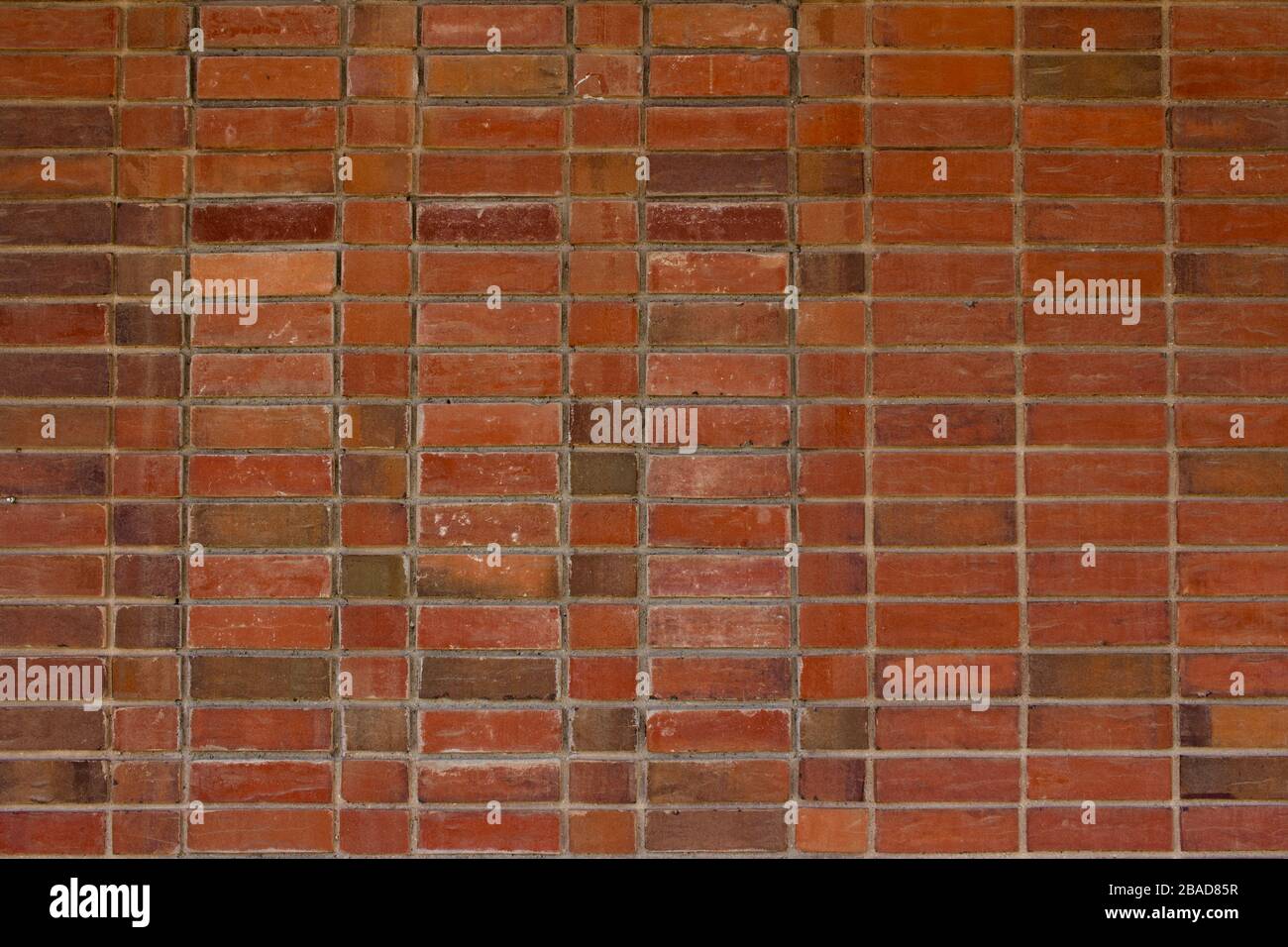 Older weathered red and brown brick wall texture background with a unique stack bond brickwork pattern. Stock Photo