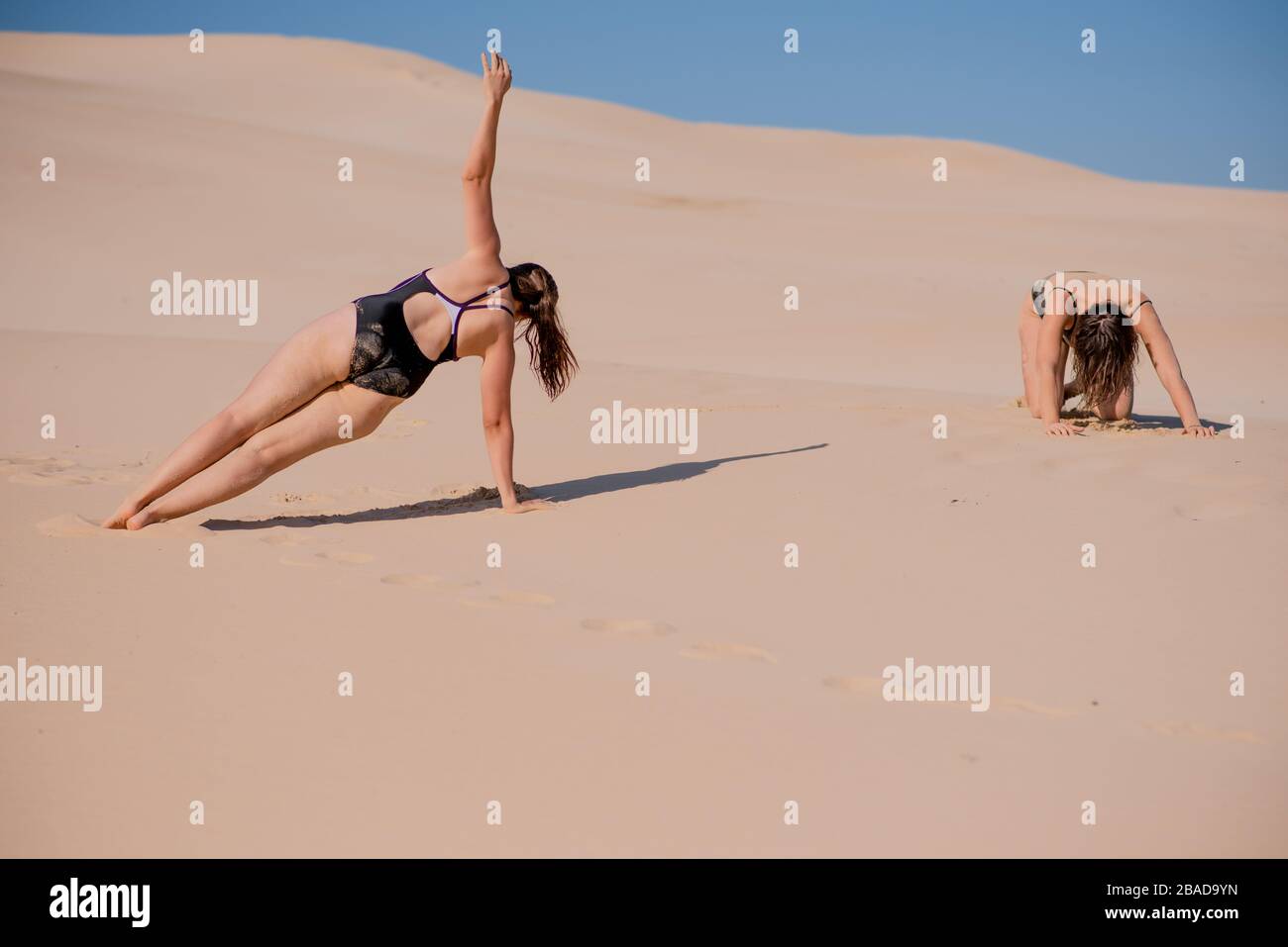 Two individuals exercising at beach Stock Photo