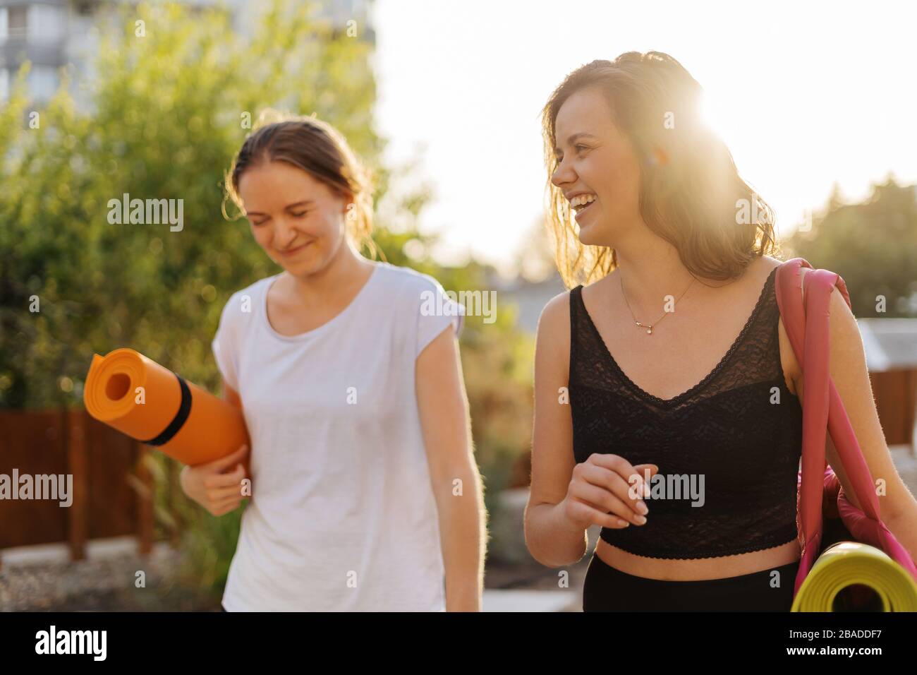 Two young beautiful women in sportswear going to do sports training, gymnastics, yoga. Healthy sports lifestyle concept. Women friendship Stock Photo