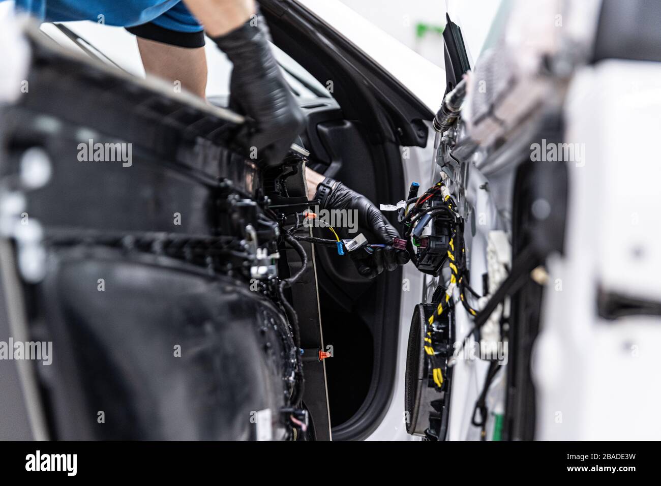 Man car factory or service worker assembles car electrical equipment