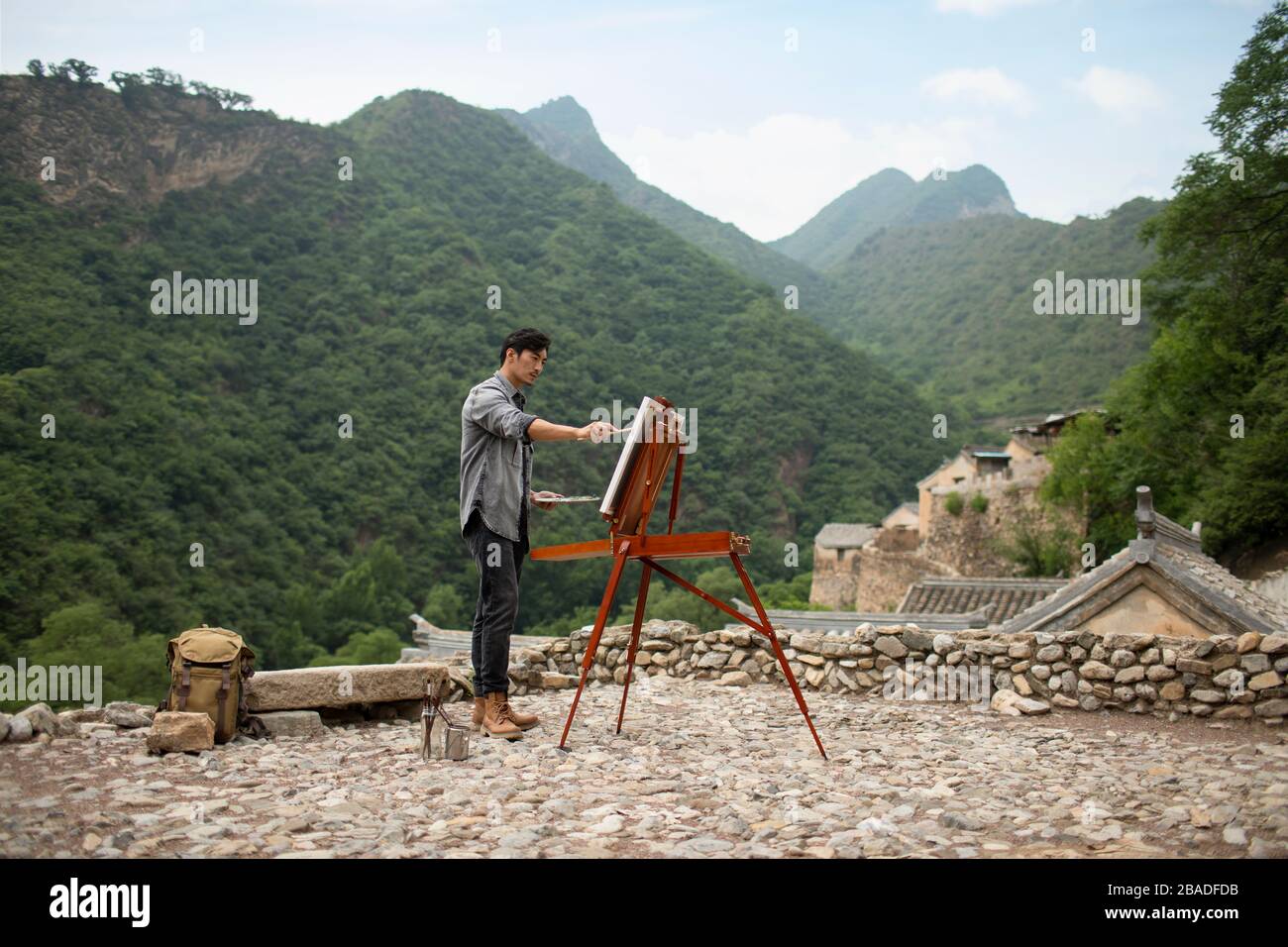 Young Chinese man painting outdoors Stock Photo