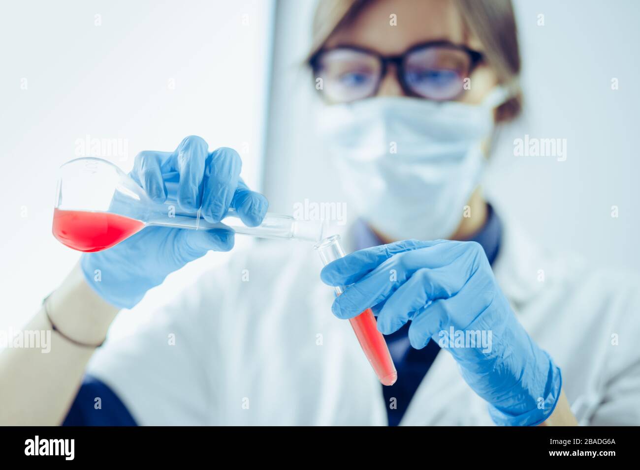 Young scientist looking through a microscope in a laboratory. Young scientist doing some research. Stock Photo