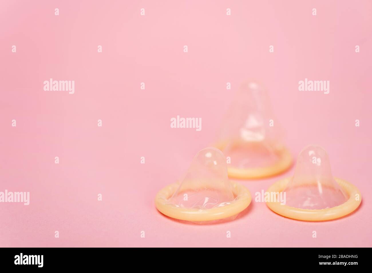 Close up view of condoms on pink background with copy space Stock Photo