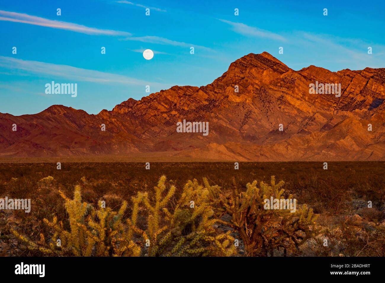 In this shot the full moon rises over a mountain range near the Kelbaker Road in the Mojave National Preserve, California, USA. Stock Photo