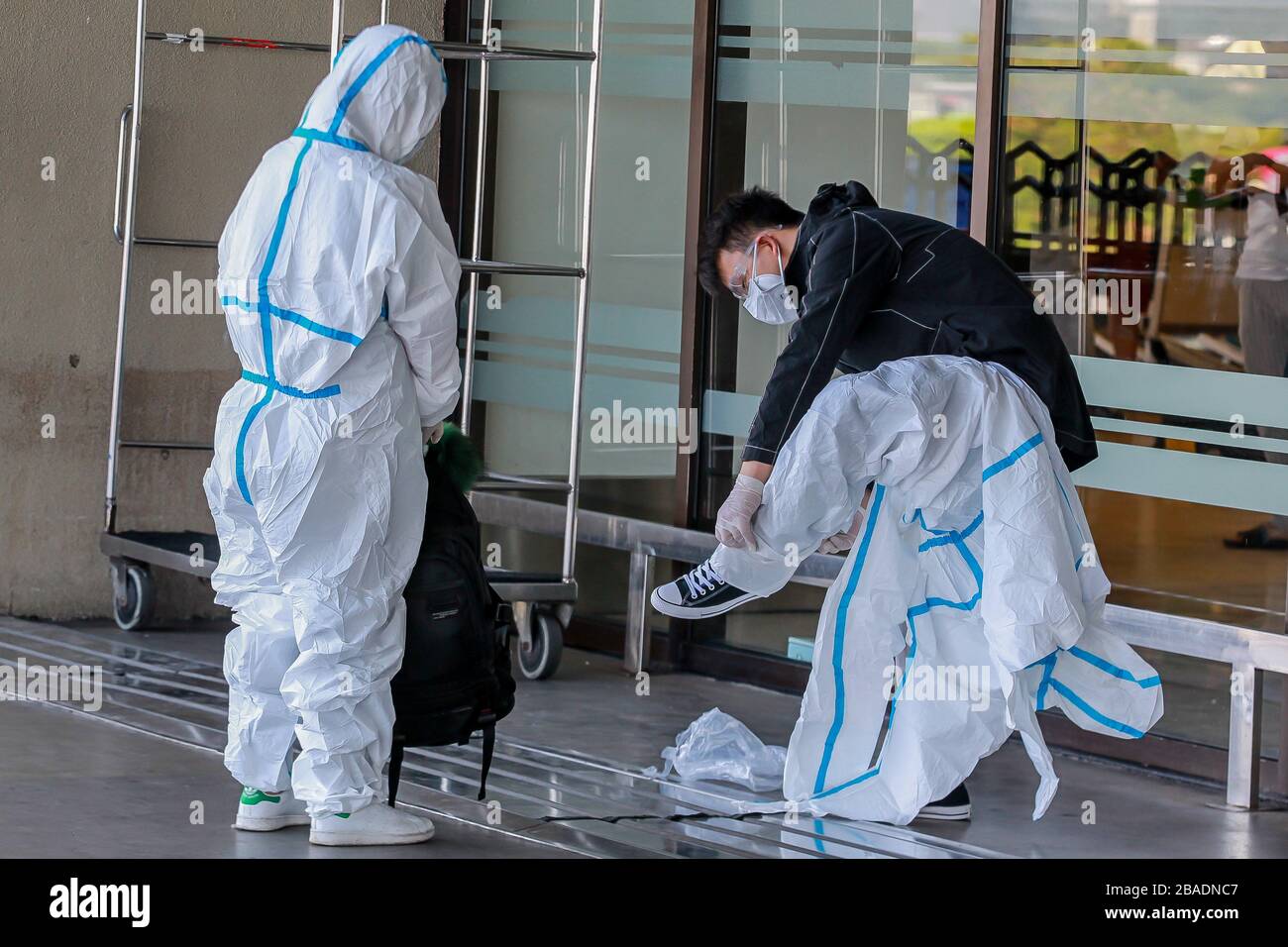 Pasay City. 27th Mar, 2020. A couple put on protective suits as they arrive for their flight at Ninoy Aquino International Airport (NAIA) in Pasay City, the Philippines on March 27, 2020. Credit: Rouelle Umali/Xinhua/Alamy Live News Stock Photo