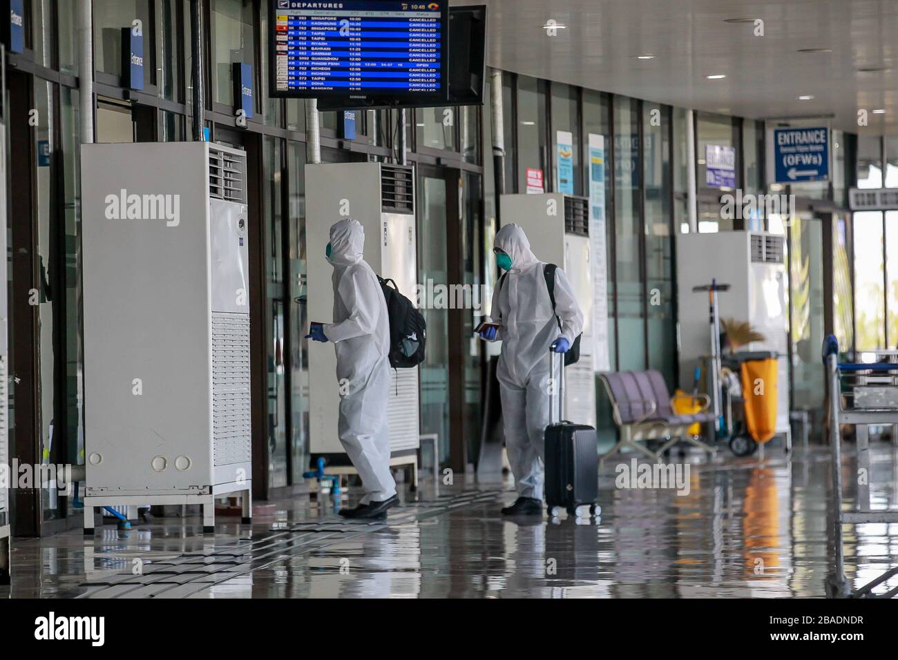 Pasay City. 27th Mar, 2020. Passengers wearing face masks and protective suits arrive for their flight at Ninoy Aquino International Airport (NAIA) in Pasay City, the Philippines on March 27, 2020. Credit: Rouelle Umali/Xinhua/Alamy Live News Stock Photo