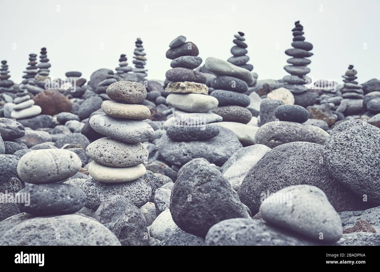 Stone stacks on a beach, color toning applied, selective focus. Stock Photo