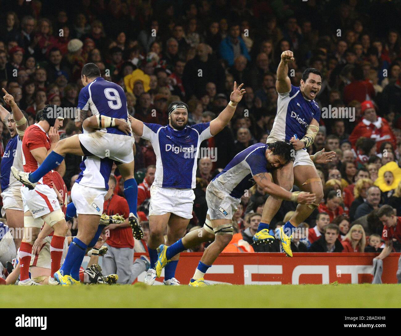 Samoa's players celebrate their win over Wales at the end of the match Stock Photo