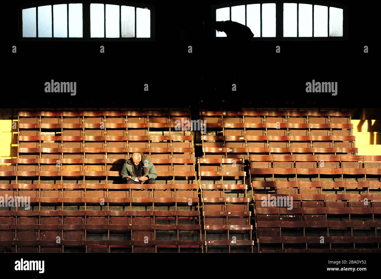 A single fan takes his seat early in the wooden seating area of Craven Cottage for the match against Sunderland Stock Photo