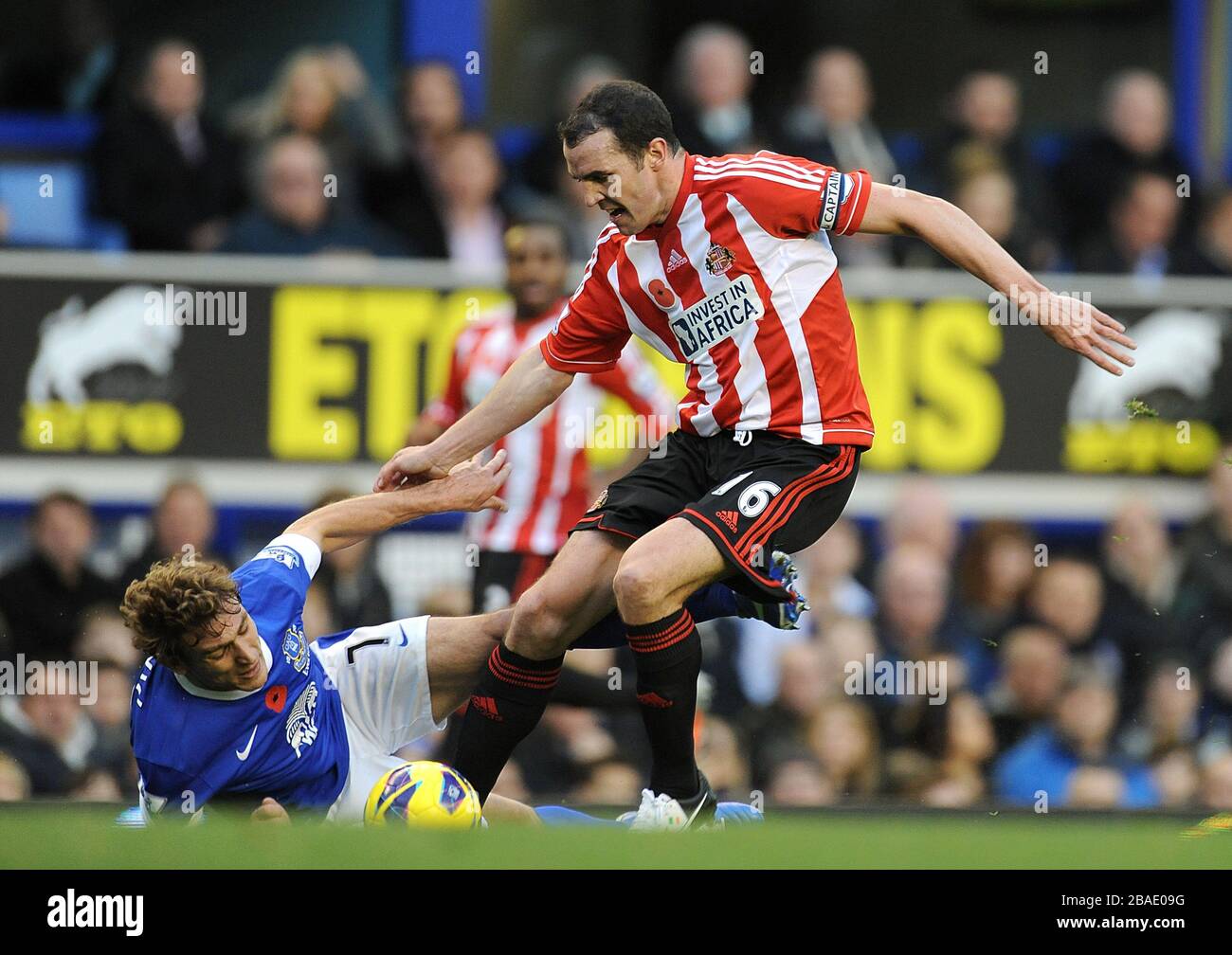 Everton's Nikica Jelavic (left) goes down under a challenge from Sunderland's John O'Shea as they battle for the ball Stock Photo