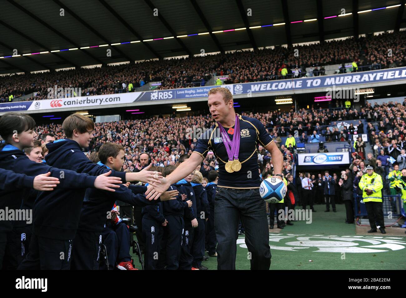 Great Britain's Olympic gold medal winner Sir Chris Hoy carries the match ball onto the pitch Stock Photo