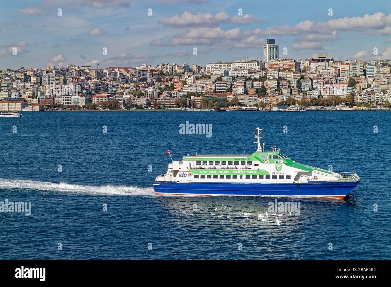 A Fast Ferry crossing the Bosphorus Straits with its Passengers, with a list of its destinations painted on to its Superstructure Stock Photo