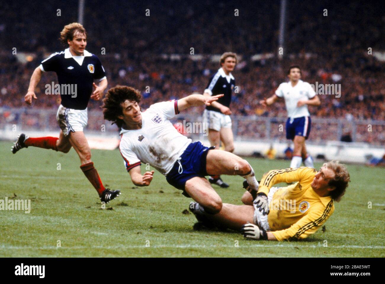 Kevin Keegan of England (centre) slides in to score despite the attempts of Scotland goalkeeper George Wood (left) Stock Photo