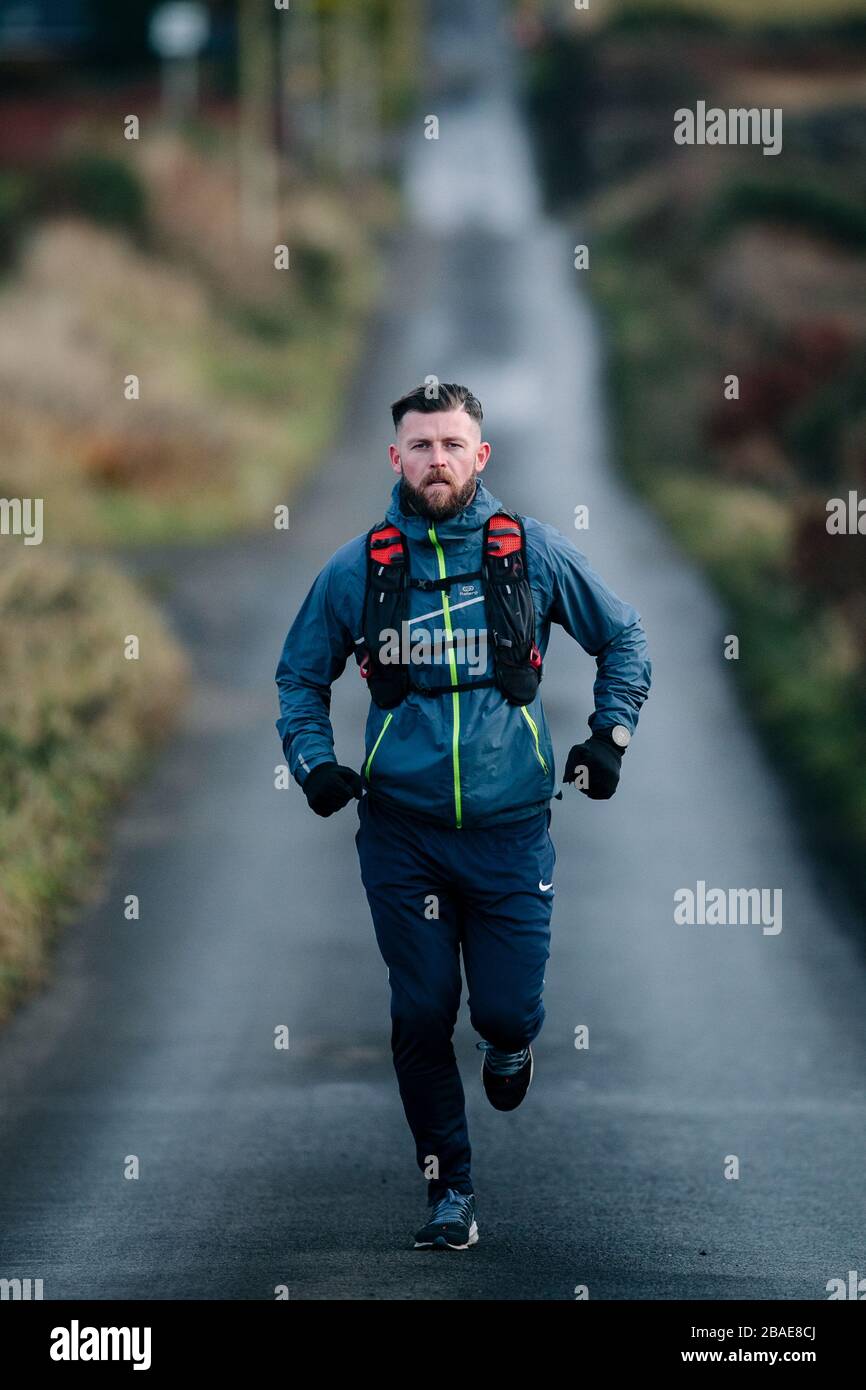 Man running on road, Glasgow, Scotland Stock Photo Alamy