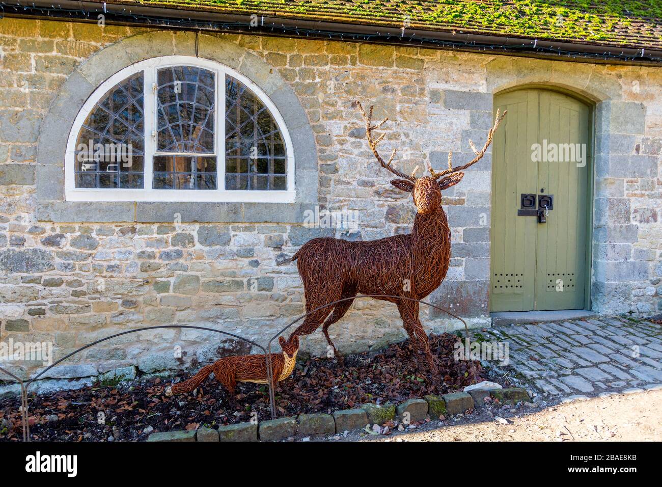 Realistic willow sculptures of a red deer stag and fox in the stable yard at Stourhead House; Wiltshire; England; UK Stock Photo