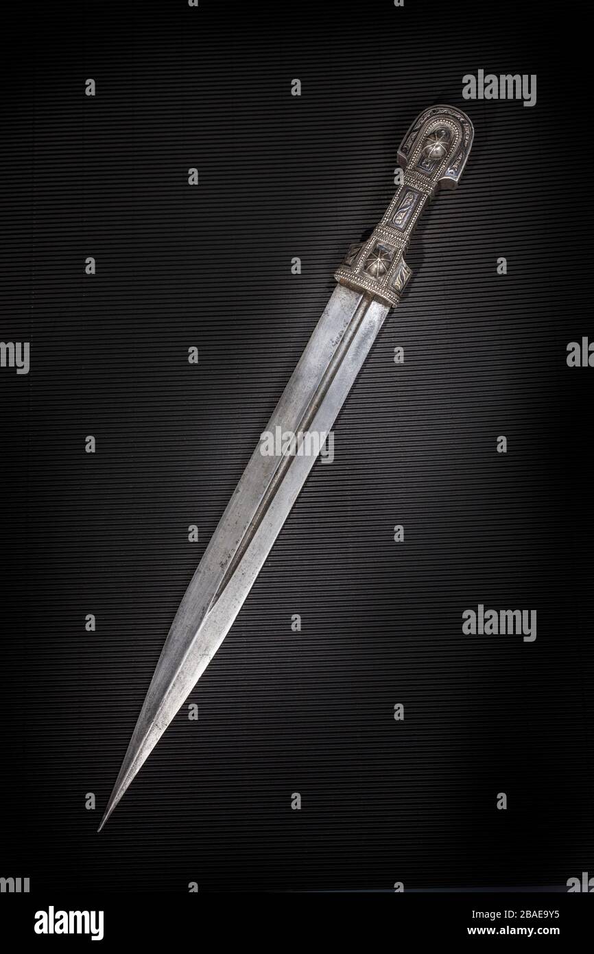 Beautiful example of caucasian dagger with blade in form of Rome sword on black paper background. 19th century (Time of Russian-Caucasian wars (1816-1 Stock Photo
