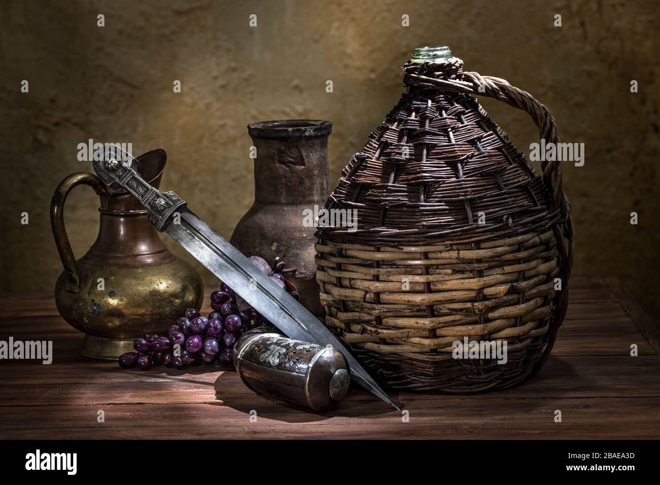 Beautiful example of caucasian dagger with willow-vine-bound bottle, silver powder flask and copper, clay jugs on wood background. 19th century (Time Stock Photo