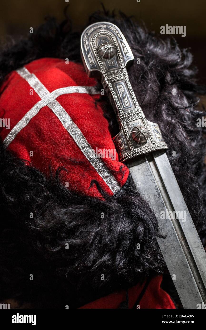 Beautiful example of caucasian dagger with red  Kuban cossack papakha. 19th century (Time of Russian-Caucasian wars (1816-1864)). Russia Stock Photo