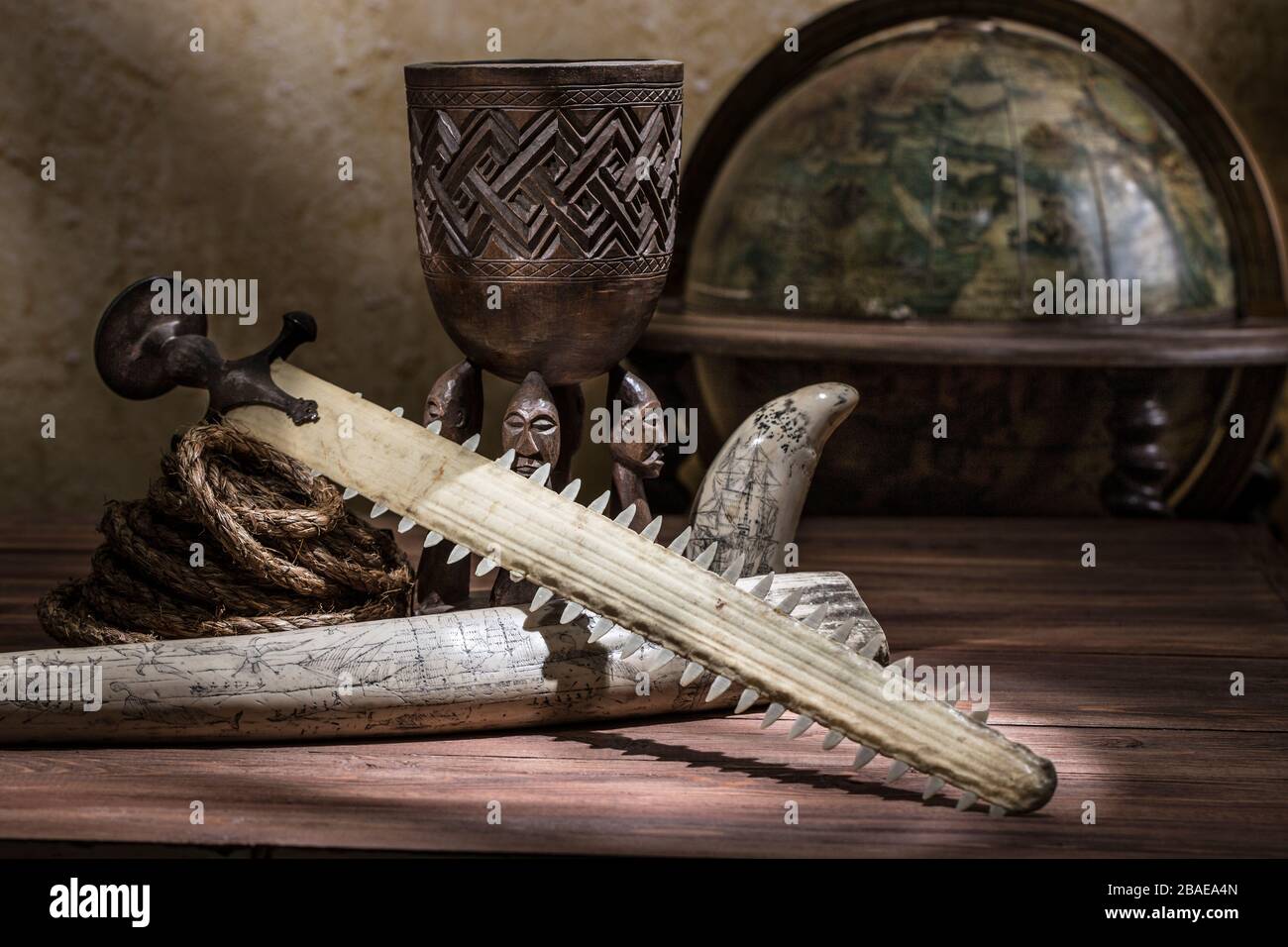 Stlll life of the 19th century sea voyage with old indian talvar (sabre), rope, globe and etching on a walrus tusk Stock Photo