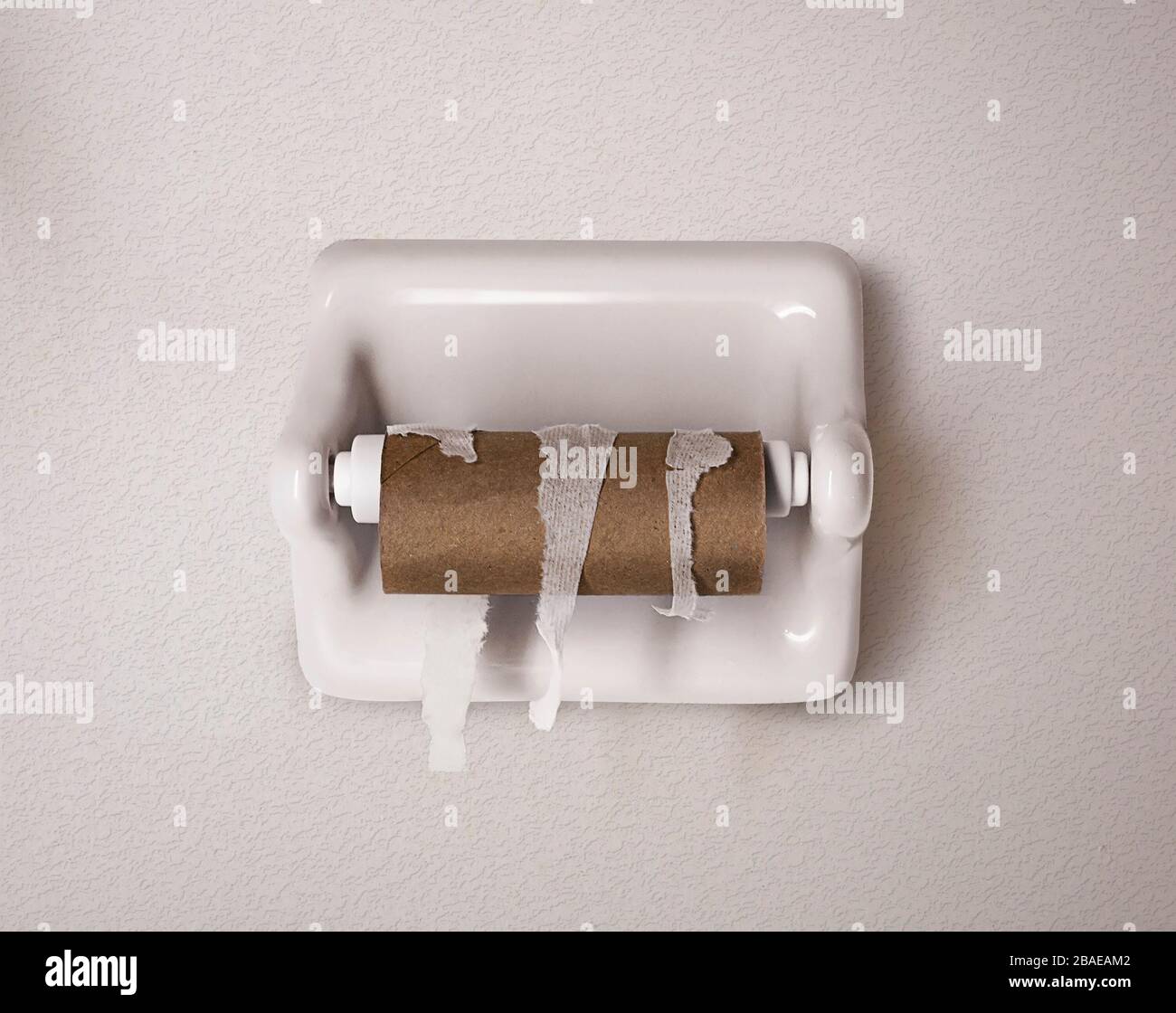 Empty toilet paper roll on white wall in bathroom Stock Photo