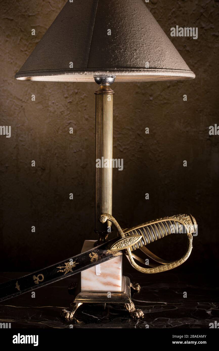 French officer saber (sabre) with retro lamp on black backgroundl.The 19th century. France. Stock Photo