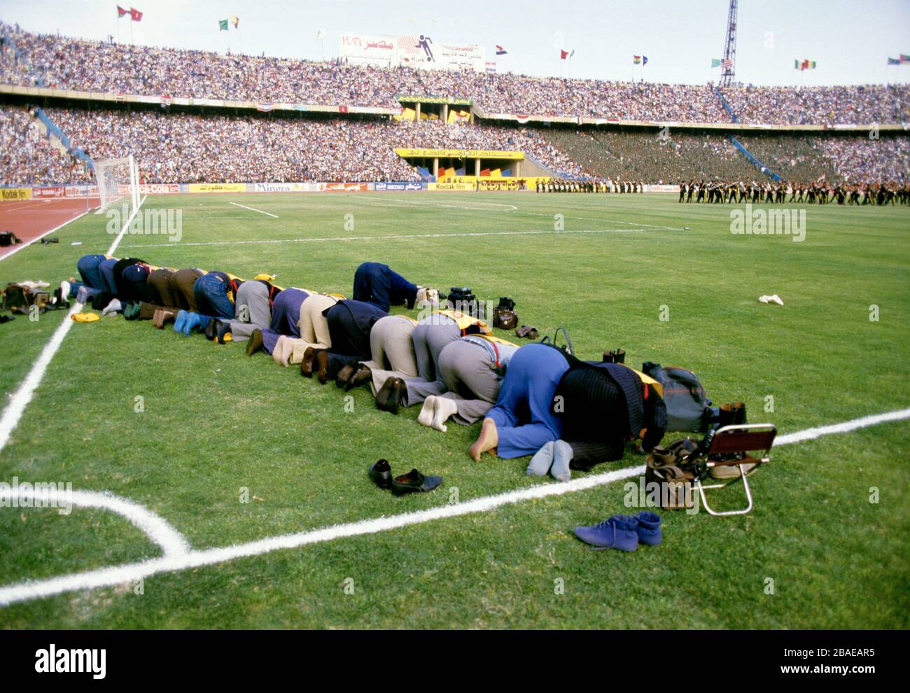 Arabian photographers praying to Mecca Stock Photo