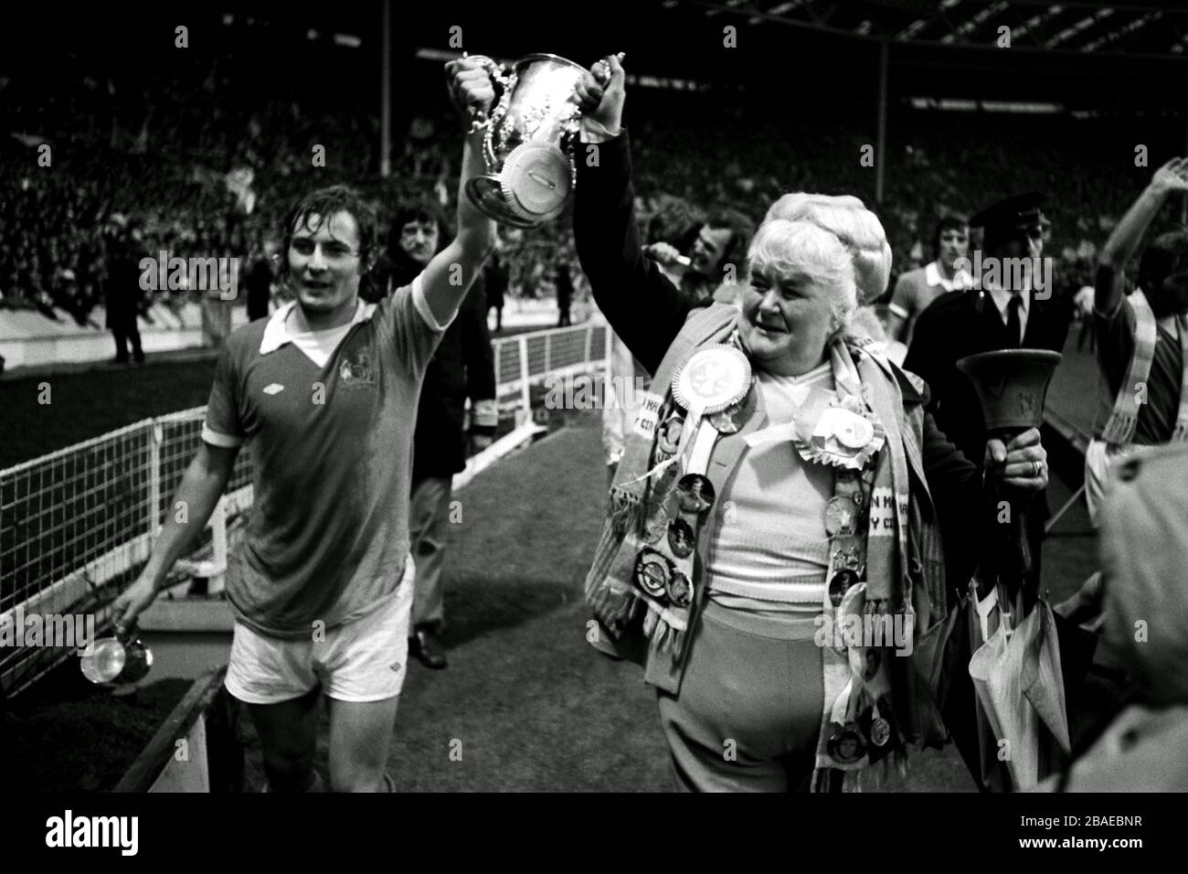 Manchester City's Asa Hartford (l) and famous fan Helen 'The Bell' Turner parade the League Cup around Wembley after their 2-1 victory Stock Photo