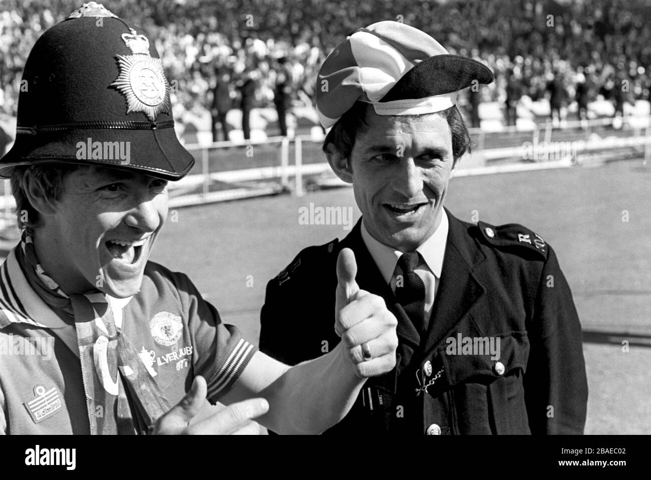 Manchester United's Gordon Hill (l) celebrates his team's victory with a policeman. Stock Photo