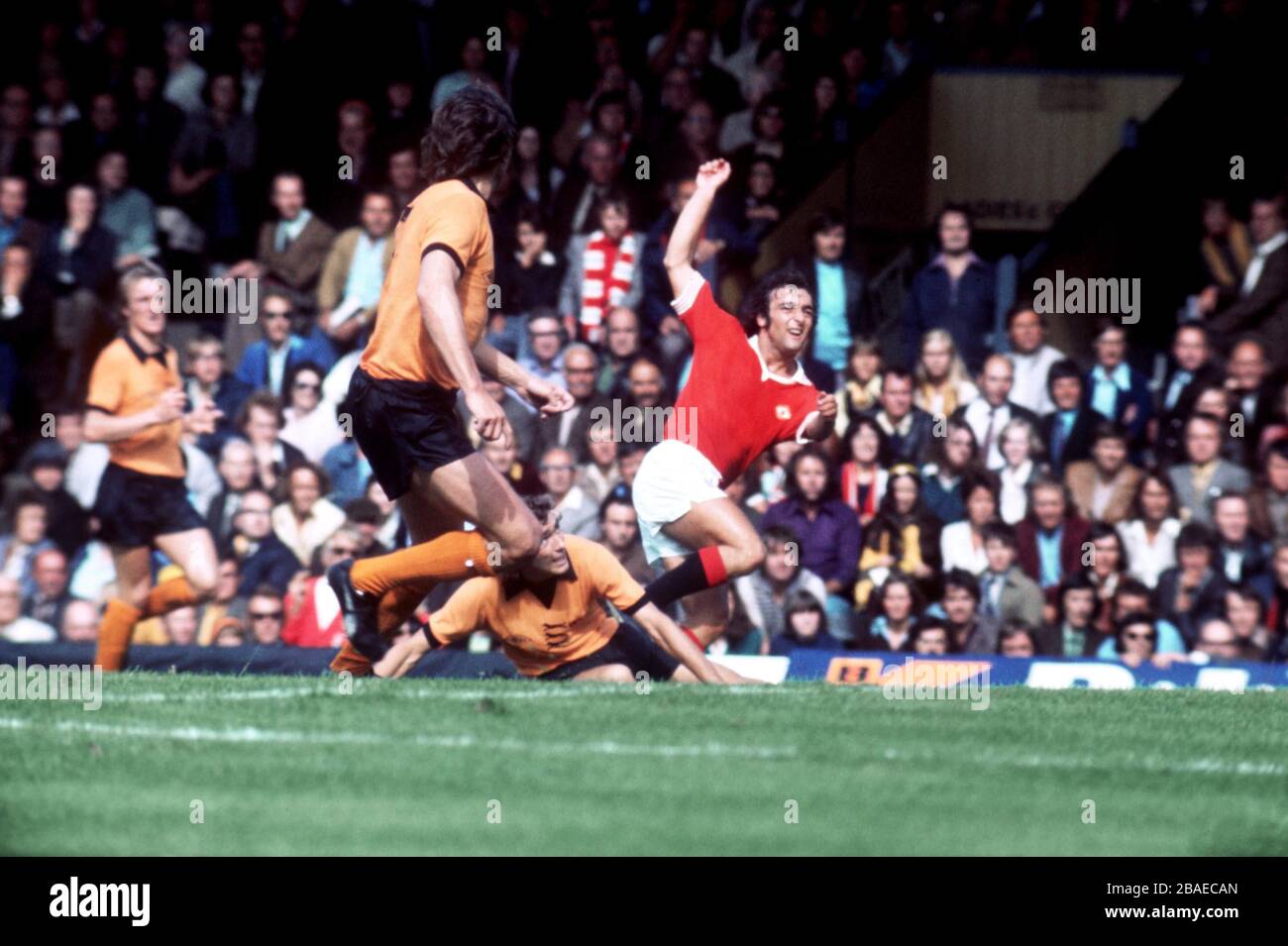 Wolverhampton Wanderers' John McAlle (on floor) slides in too late to prevent Manchester United's Lou Macari (r) from scoring Stock Photo
