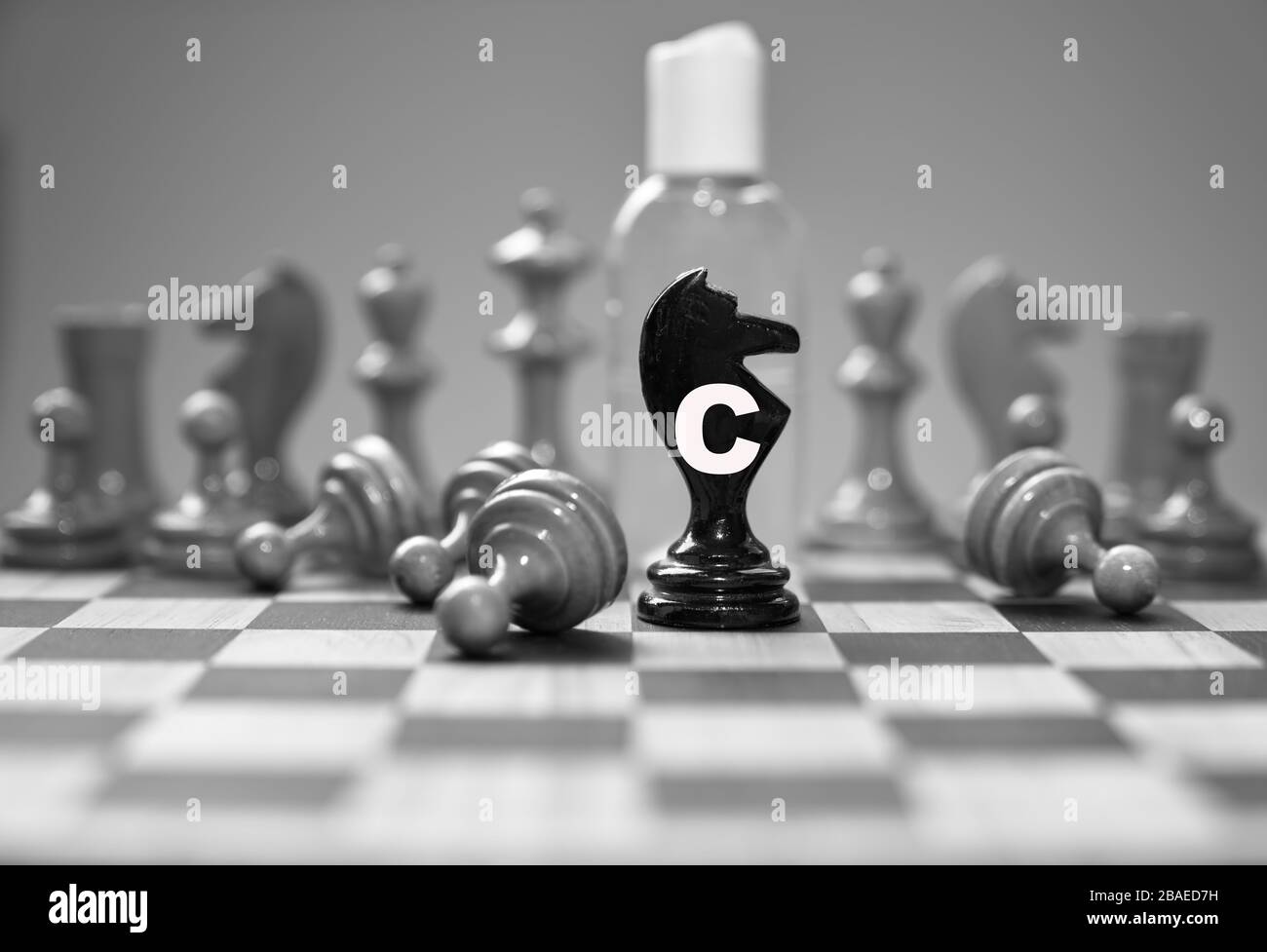 Coronavirus concept image chess pieces and hand sanitizer on chessboard illustrating global struggle against novel covid-19 outbreak. Stock Photo