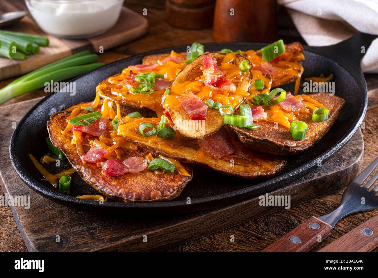 Delicious homemade potato skins with melted cheese, bacon, green onions and sour cream. Stock Photo