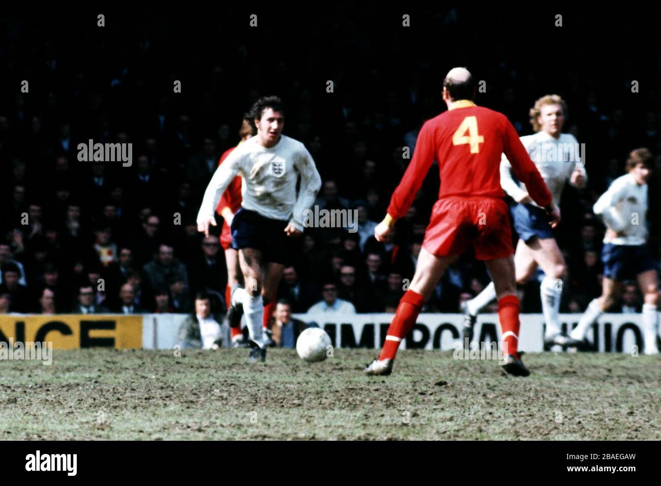 England's Roy McFarland (l) brings the ball forward, watched by Wales's Terry Hennessey (r) Stock Photo