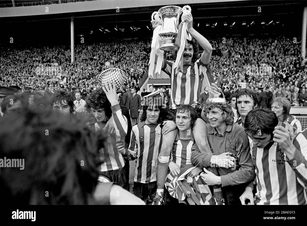 Sunderland captain Bobby Kerr (top) holds the FA Cup aloft after his team's 1-0 victory, supported by teammates (l-r) Billy Hughes, Dennis Tueart and goalkeeper Jim Montgomery Stock Photo