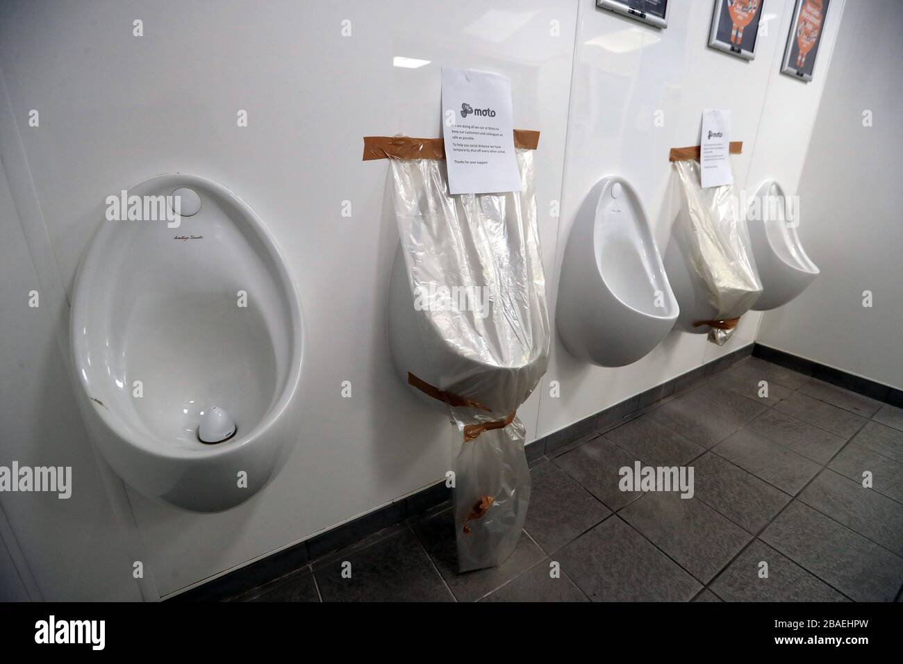 Signs on urinals at Moto services in Melton Mowbray as the UK continues in lockdown to help curb the spread of the coronavirus. Stock Photo