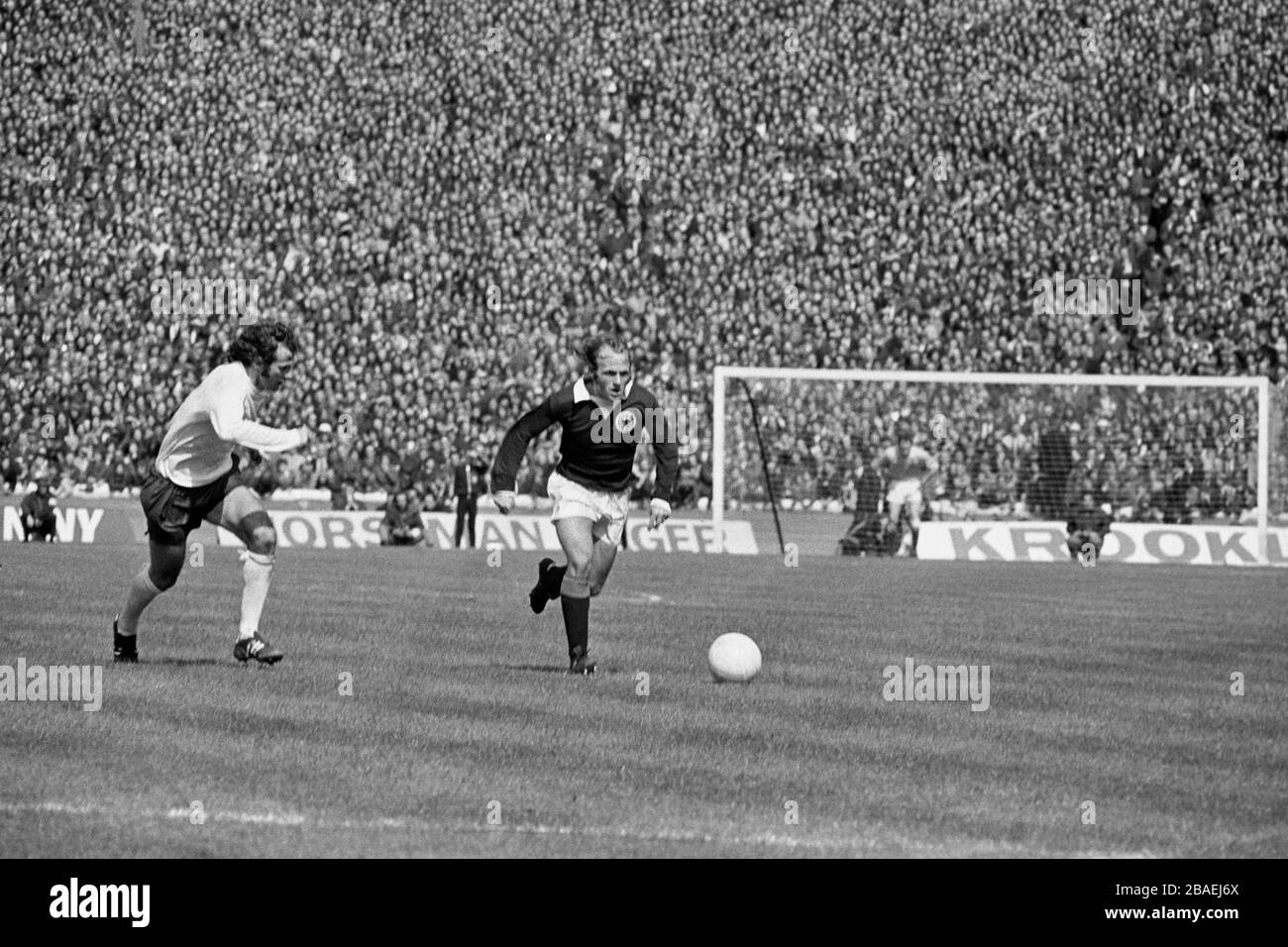 Scotland's Archie Gemmill (r) carries the ball forward as England's Peter Storey (l) pursues Stock Photo