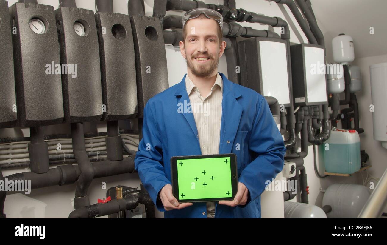 Young engineer smiling at camera with tablet Stock Photo
