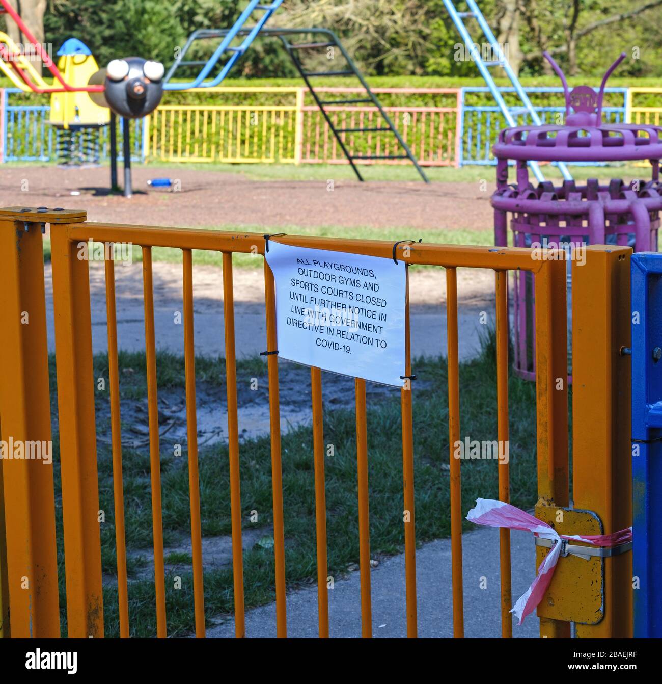 Closure notice on playground gate tied shut as social distancing takes effect during Coronavirus Covid19 pandemic, Pinner Memorial Park, Harrow London Stock Photo