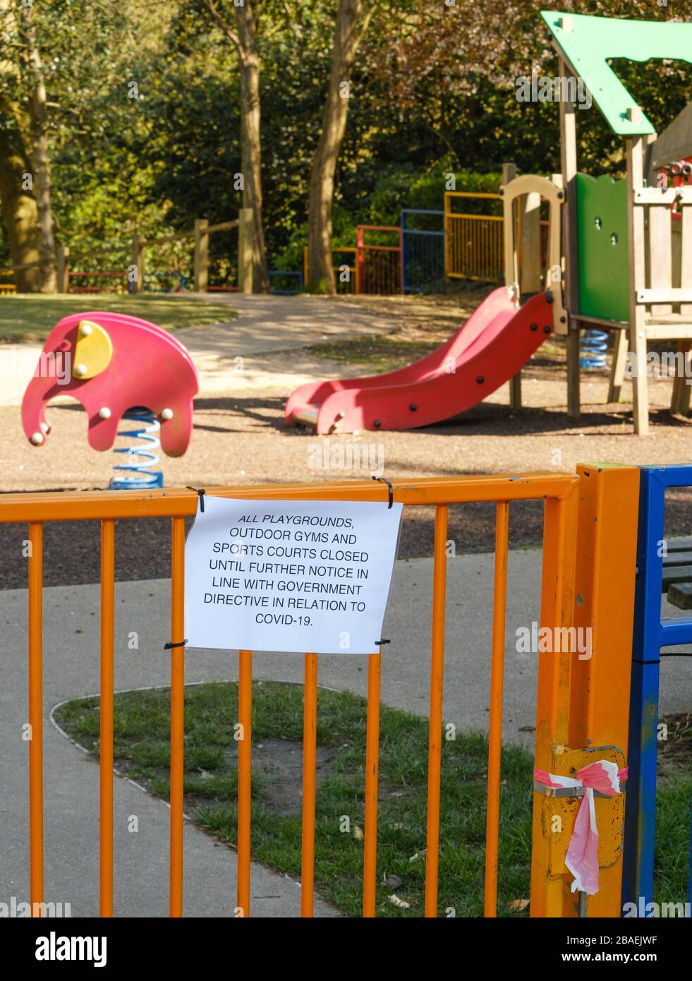 Closure notice on playground gate tied shut as social distancing takes effect during Coronavirus Covid19 pandemic, Pinner Memorial Park, NW London, UK Stock Photo