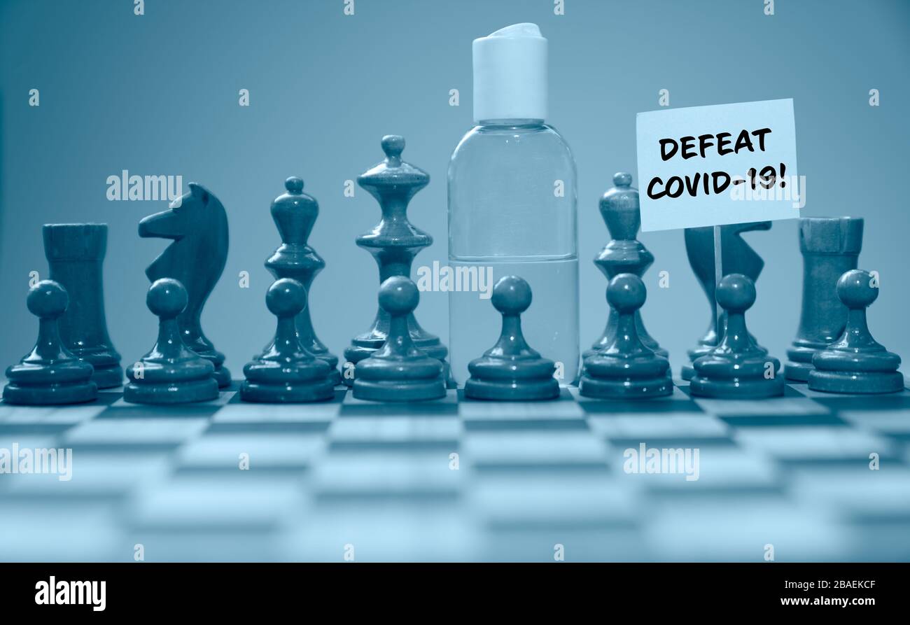 Coronavirus concept image chess pieces and hand sanitizer on chessboard illustrating global struggle against novel covid-19 outbreak with defeat covid Stock Photo