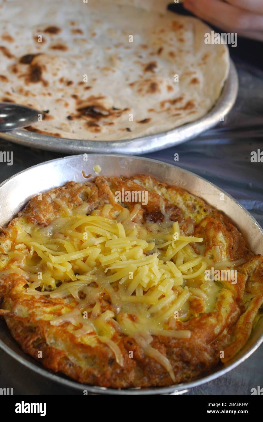 Bahraini breakfast of eggs with cheese and traditional Arab flat bread ...