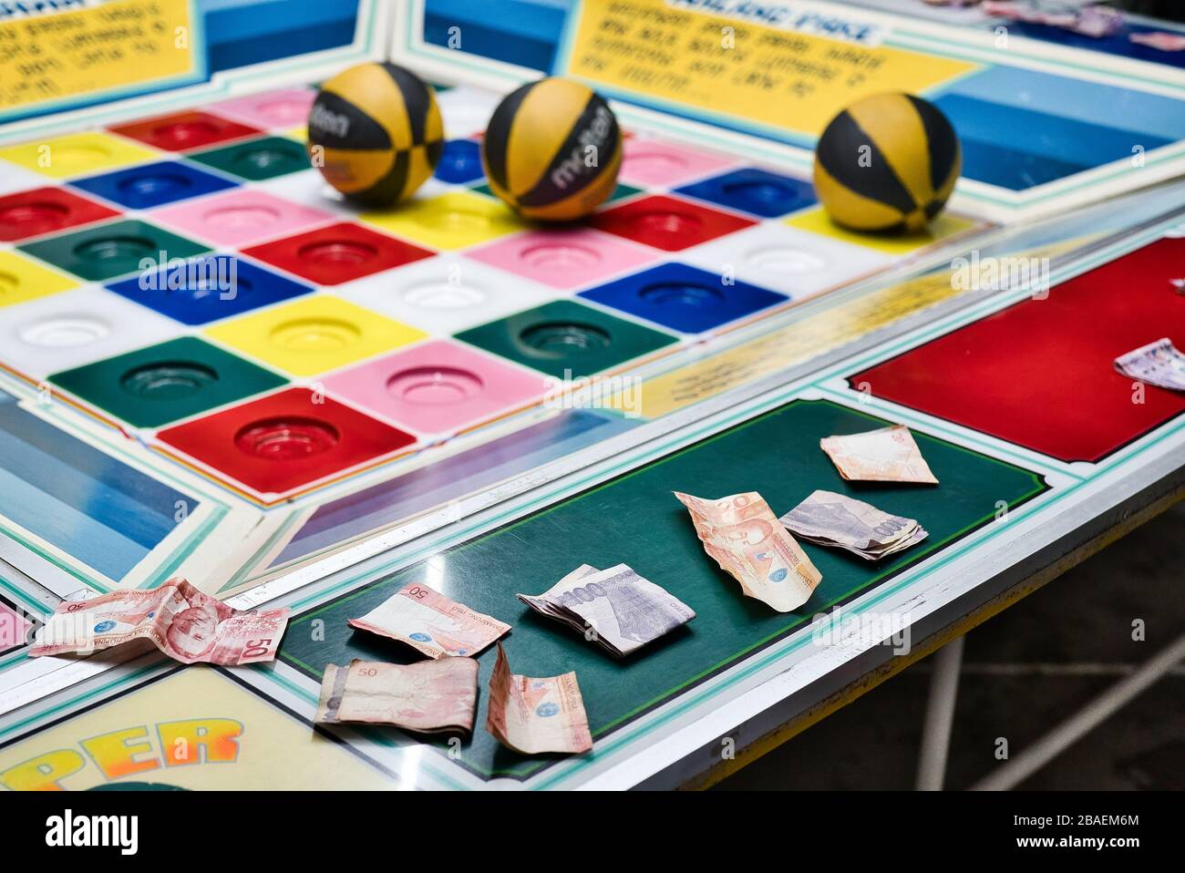 Various handspeople betting on a game of chance in the Philippines