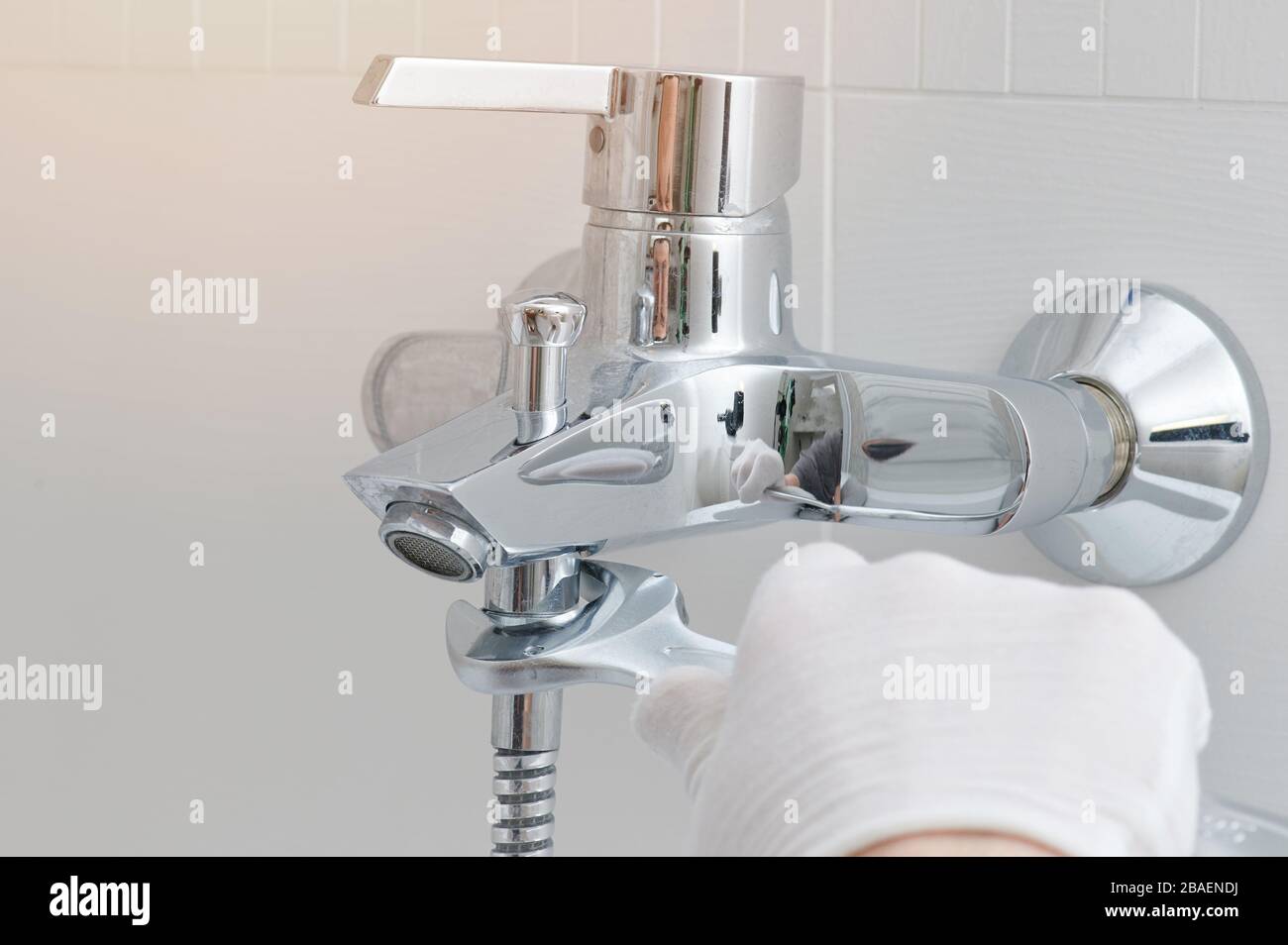 Fixing faucet in bathroom. Hand with wrench installing tap Stock Photo