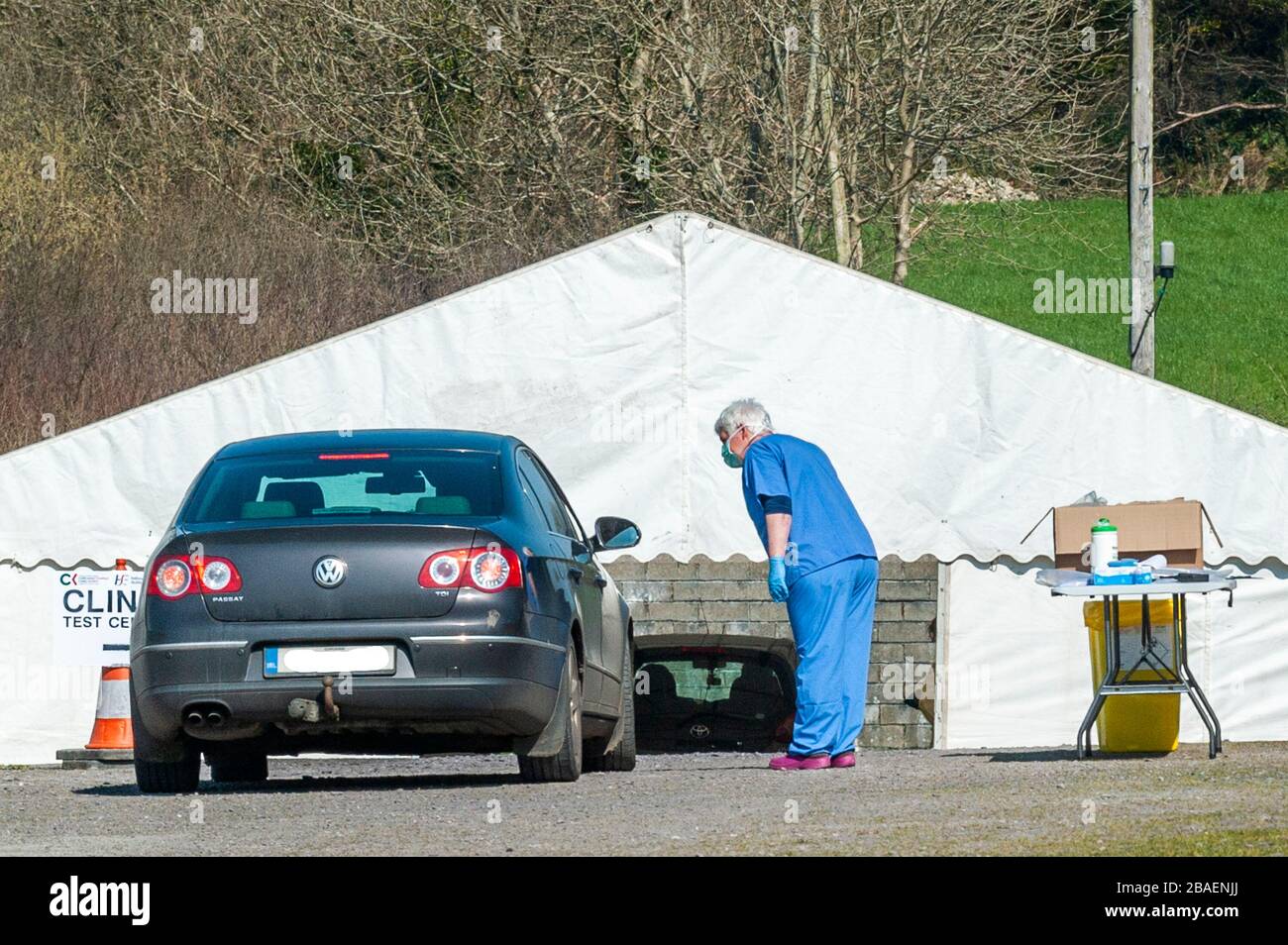 Ballynacarriga, West Cork, Ireland. 27th Mar, 2020. A healthcare worker talks to the driver of a car who has travelled to the COVID-19 Swab/Testing Centre in Randal Og GAA Club for the occupants to be tested for the Coronavirus. The testing station was originally in Dunmanway Community Hospital but was moved yesterday in the interests of the health of elderly patients. The centre is the only such facility in West Cork. Credit: AG News/Alamy Live News Stock Photo