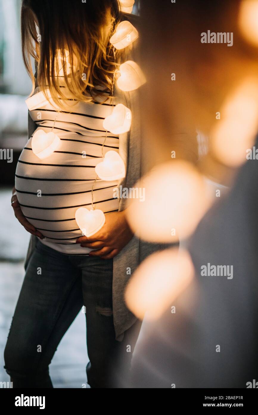 pregnant young woman holding her belly at home Stock Photo - Alamy