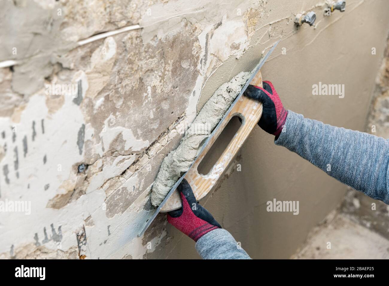 wall alignment - construction worker working with trowel and plaster Stock Photo