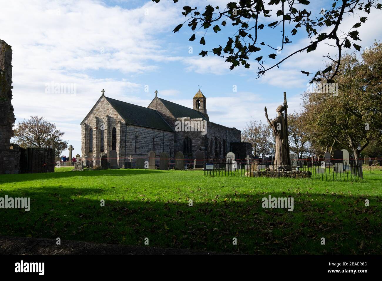 The Parish Church of Saint Mary the Virgin and statue of St Aidan, Lindisfarne Priory, Holy Island; Northumberland; England Stock Photo