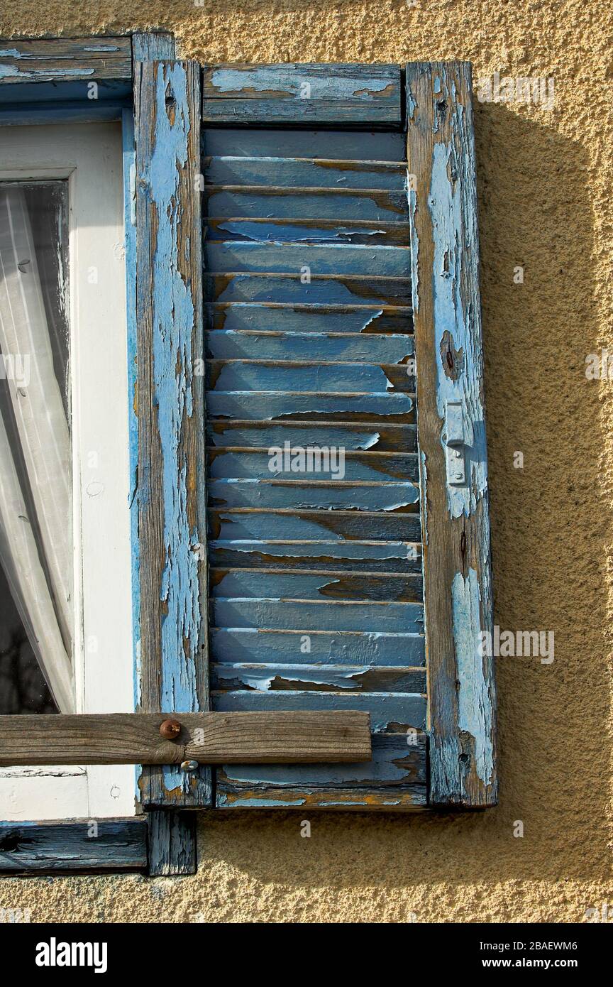 Old window shutters on a house in Cyprus, with blue paint peeling off ...