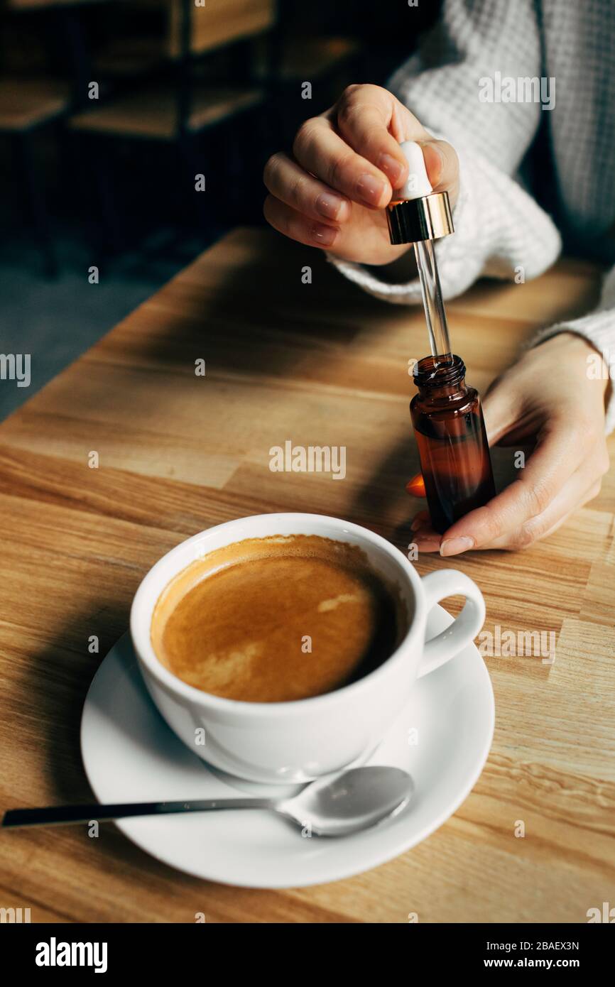Adding CBD oil in a coffee cup Stock Photo