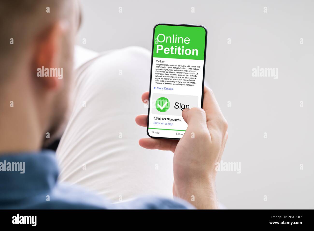Man Looking At Online Petition Form On Smartphone Stock Photo
