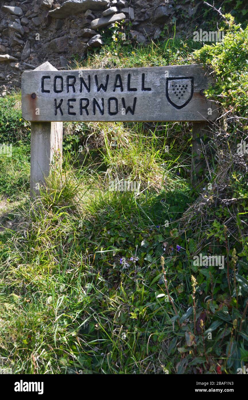 Wooden County Border Signpost for Devon/Cornwall (Kernow) near the Bridge at Marsland Mouth on the South West Coast Path, North Devon. England, UK. Stock Photo